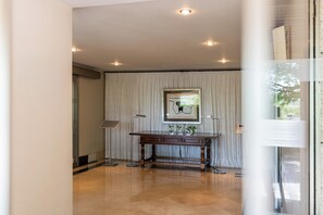 A room with a wooden desk, a framed artwork, and a floor lamp. - Parador de Puebla de Sanabria (Puebla de Sanabria)