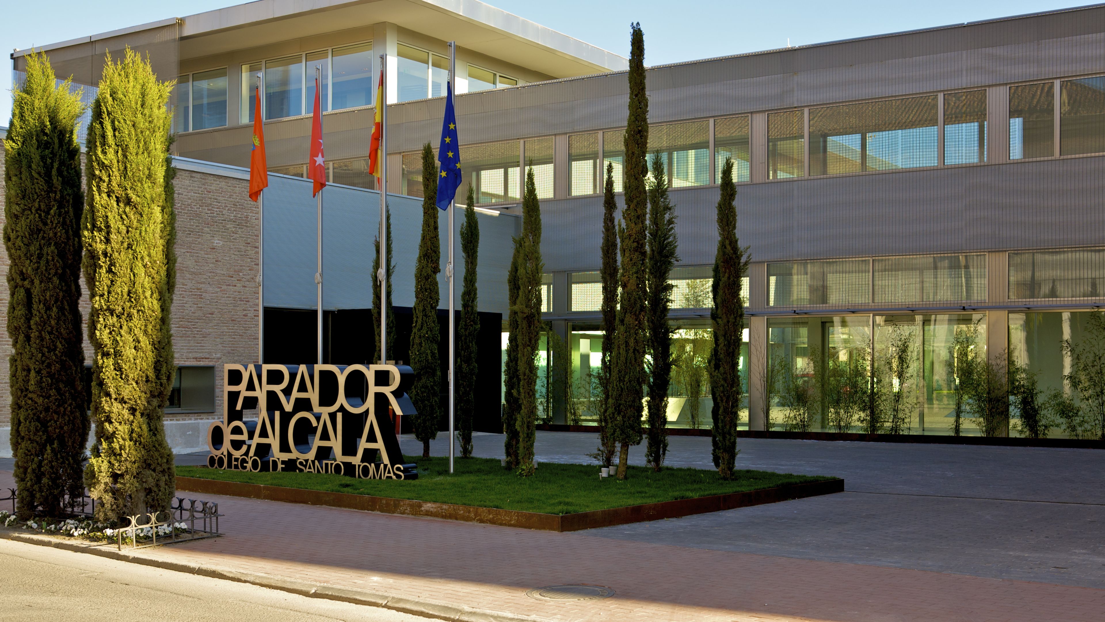 A modern building with a sign reading "PARADOR DE SALTOS" and multiple flags.