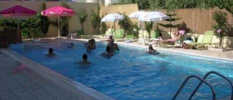 Alberca al aire libre y camastros