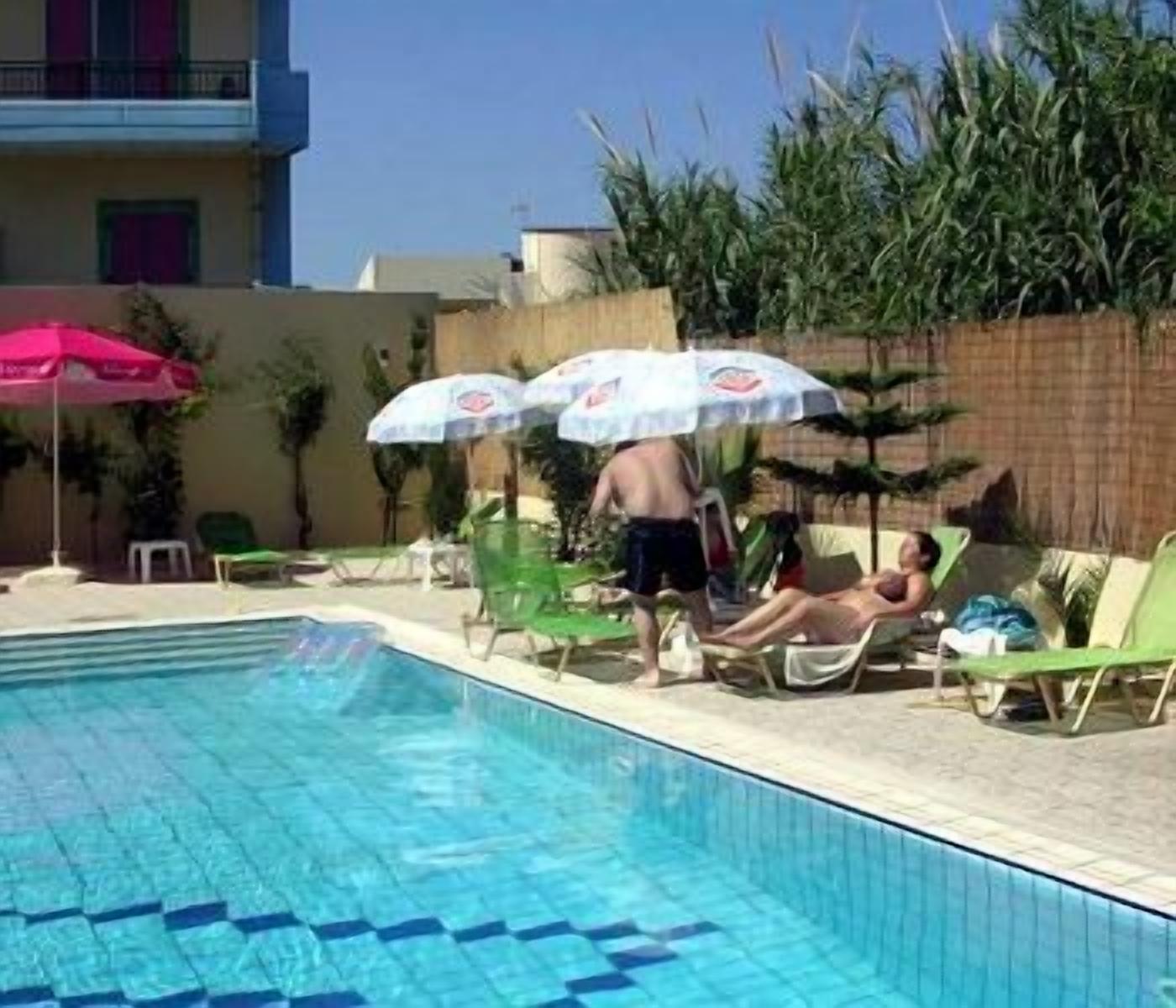 A swimming pool with lounge chairs and umbrellas.