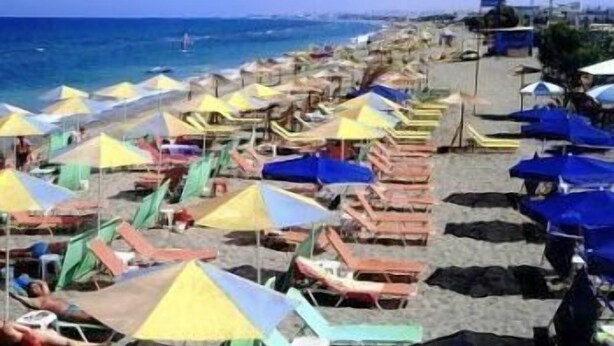 A beach with rows of colorful umbrellas and beach chairs. - Eleni Palace (Malevizi)