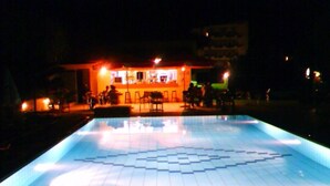 A swimming pool with a geometric tile pattern at night. - Eleni Palace (Malevizi)