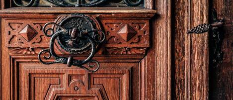 A wooden door with intricate carvings and a metal handle.