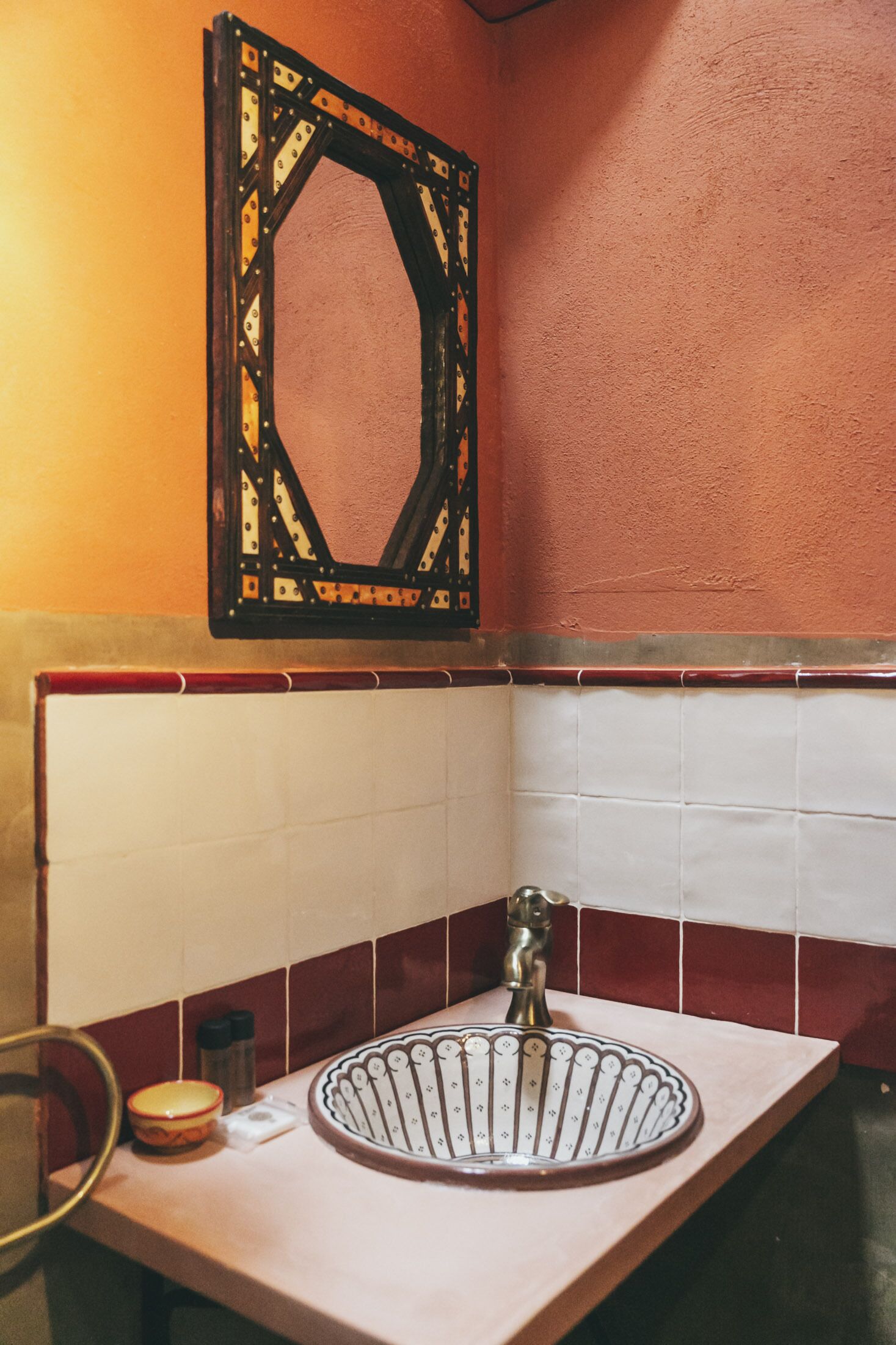 Une salle de bain avec un lavabo, un miroir et des murs carrelés.