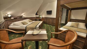 A cozy room with two beds, a dining table, and two chairs.
