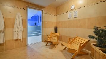 A bathroom with wooden chairs, a clock, and a potted plant.
