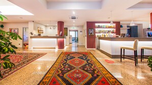 A hotel lobby with a reception desk, bar area, and a patterned carpet. - Hotel Bonotto (Desenzano del Garda)