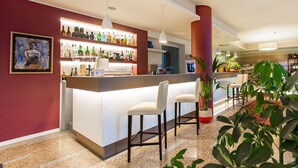 A bar area with a counter, bar stools, and shelves of bottles. - Hotel Bonotto (Desenzano del Garda)
