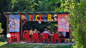 A children's play area with a colorful sign reading "MINCLUB" and cartoon characters.
