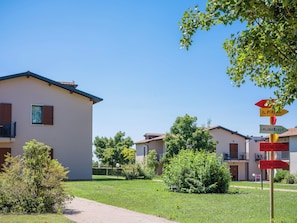 A residential area with houses, a signpost with directions, and a pathway. - Residence Eden (Castelnuovo del Garda)
