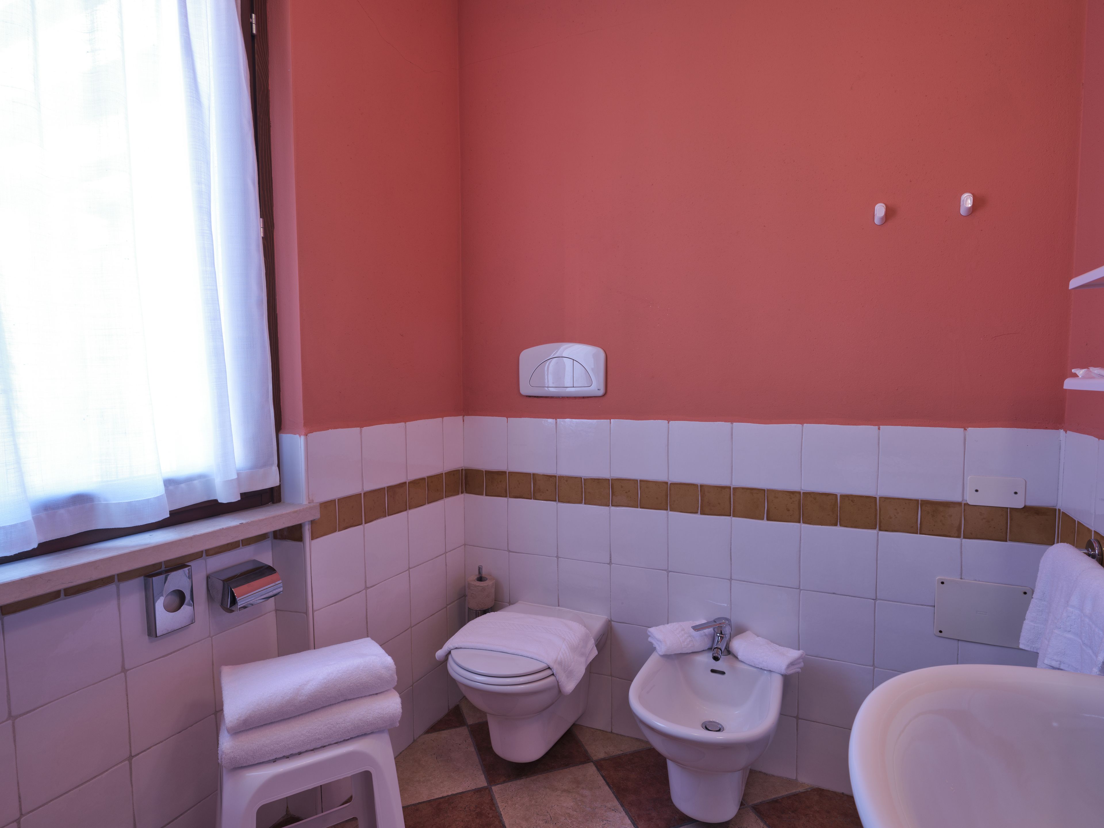 A bathroom with a toilet, bidet, and sink.