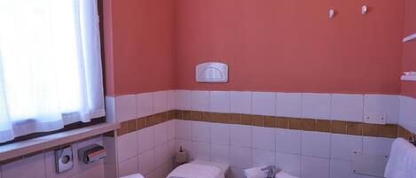 A bathroom with a toilet, bidet, and sink.