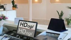 Un mostrador de recepción con un letrero que dice "HDogi HDogi", una computadora portátil e impresora.