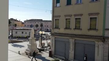 Une vue de rue avec une statue, un magasin fermé et un scooter garé.