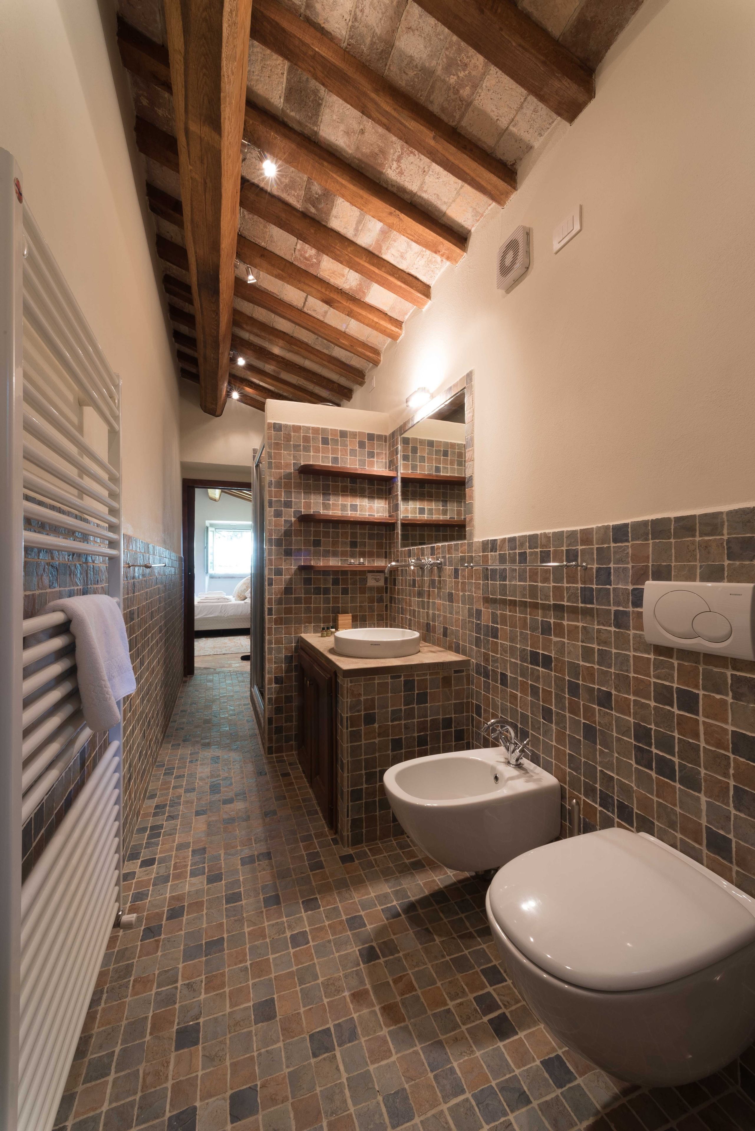 Een badkamer met betegelde vloer, een wastafel, een toilet en een bidet.