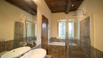 Une salle de bain avec deux lavabos, une douche et une fenêtre.