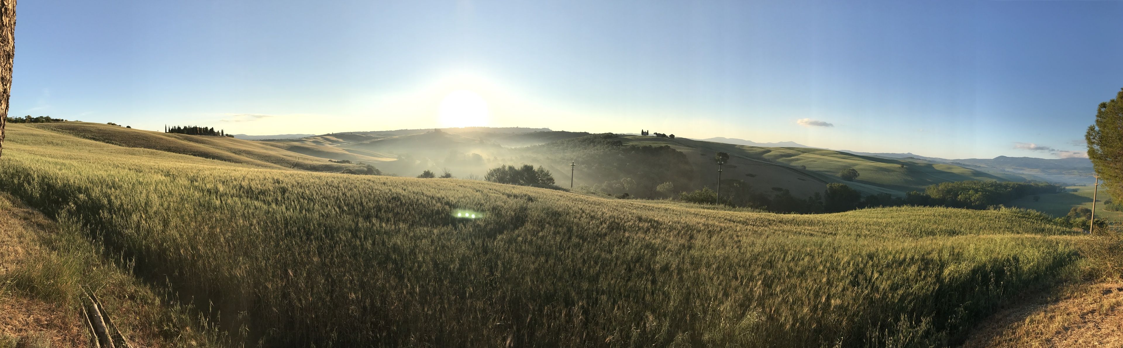 Vista panorámica de un paisaje montañoso con cielo despejado y luz solar.