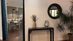 A modern interior with a console table, a potted plant, and a mirror on the wall. - Hotel Le Keroman (Lorient)