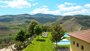 A view of a vineyard with a swimming pool and a building with a tiled roof. - Hotel Rural Quinta do Silval (Alijó)