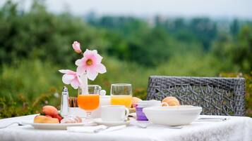 A breakfast setup with a table, a wicker chair, and a scenic outdoor background.