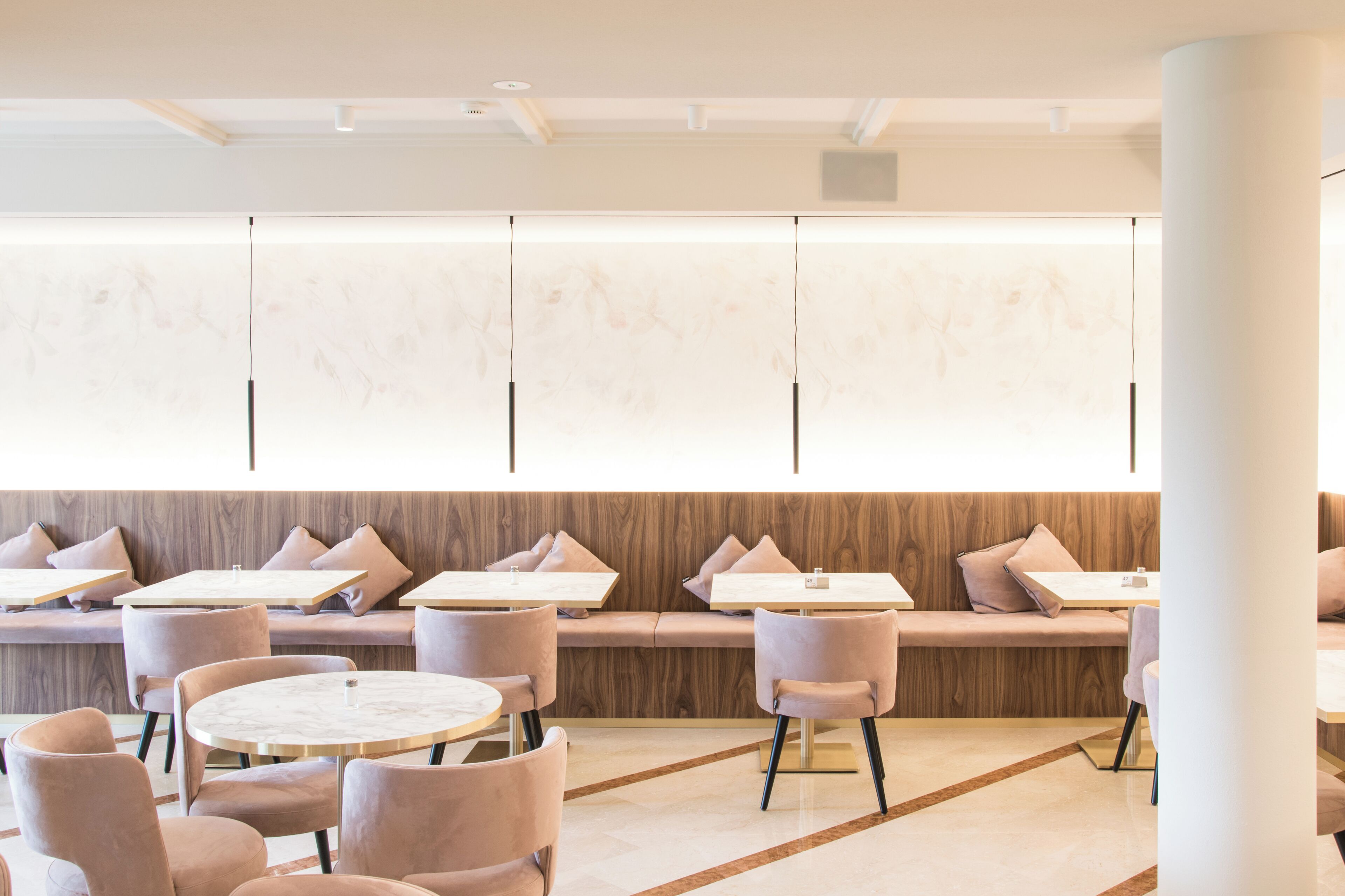 Un café moderne avec des tables rondes et des sièges rembourrés.