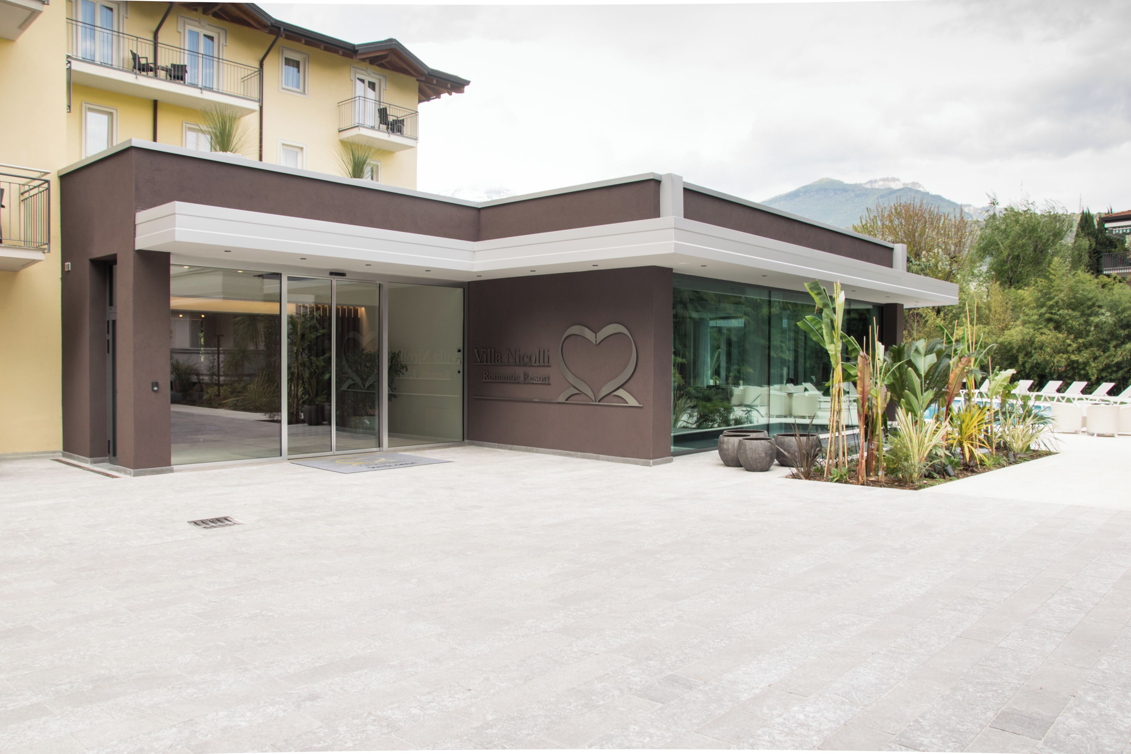 A modern building with a glass entrance and a heart-shaped logo.