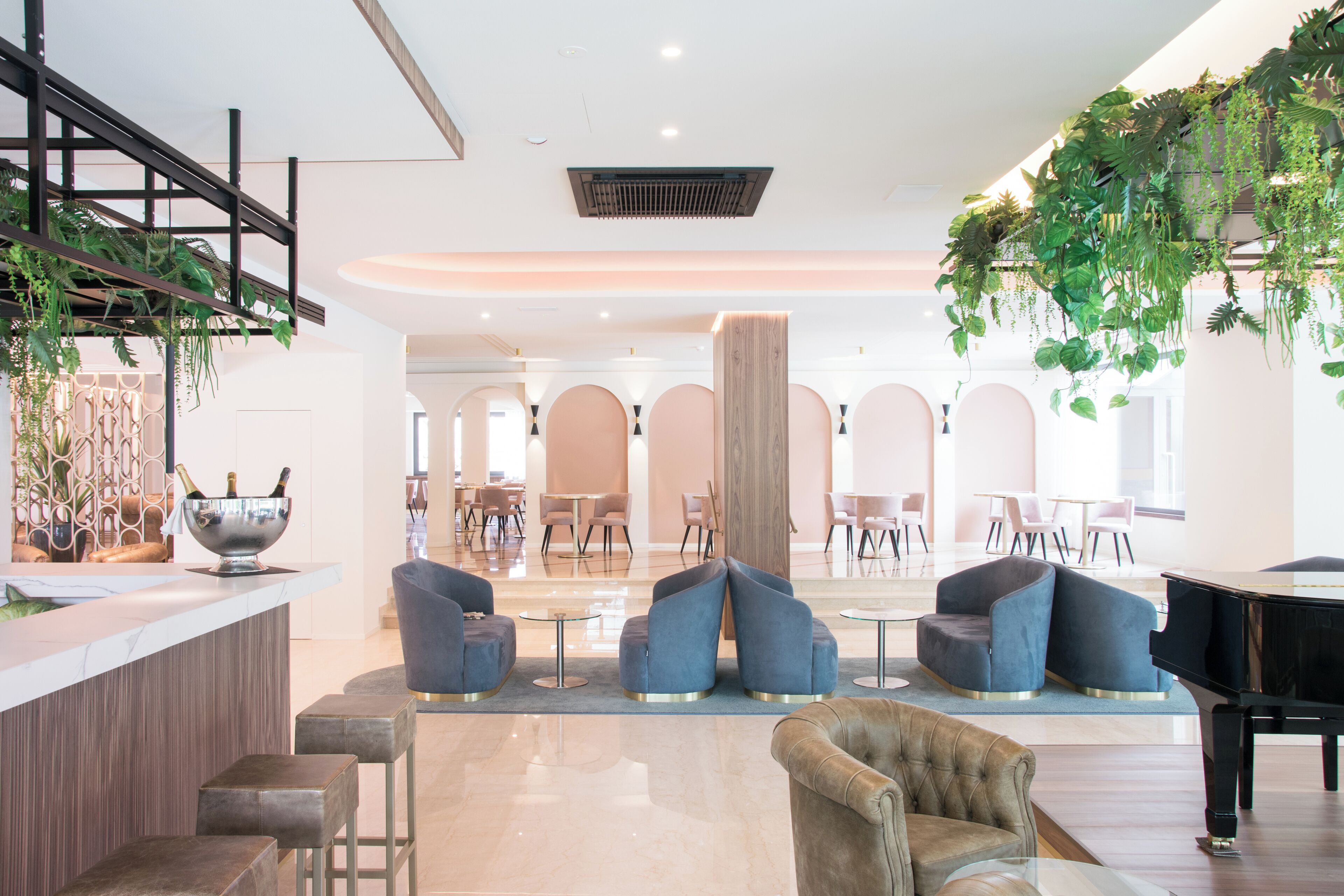 Un hall d’entrée spacieux avec un piano, des coins salon et un bar.