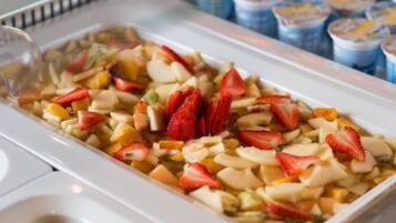 Ensalada de frutas con fresas y manzanas en un plato blanco.