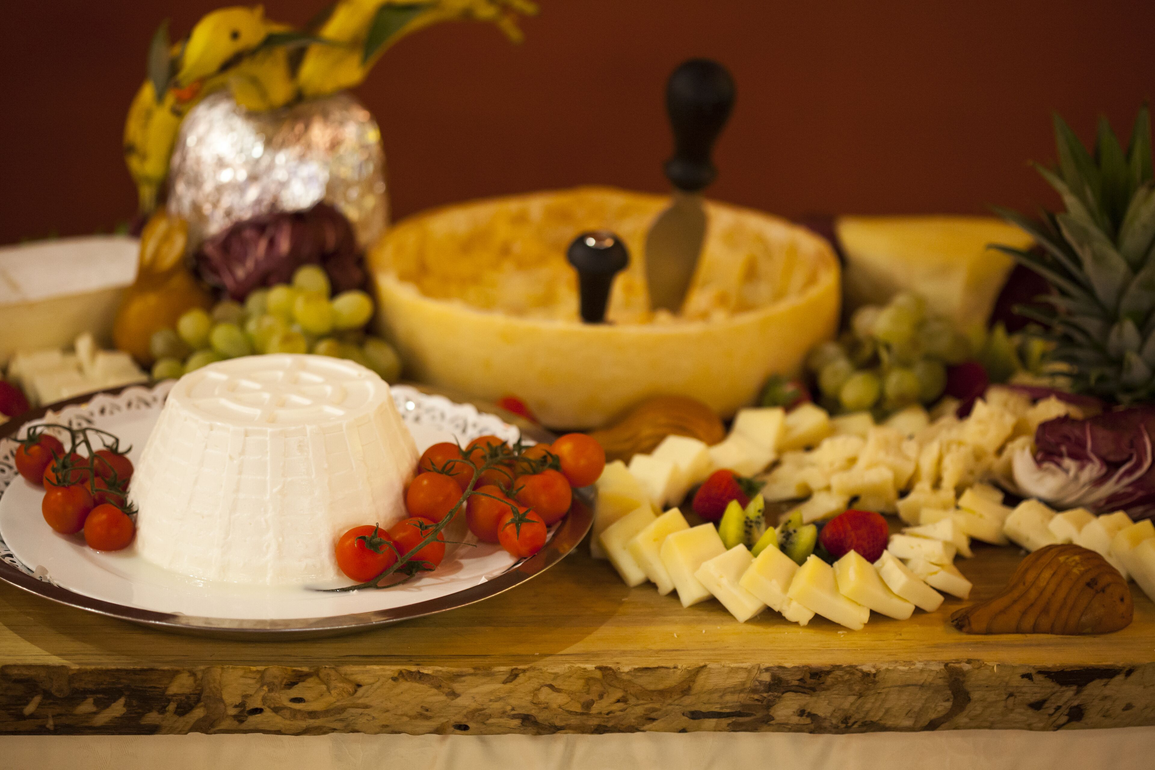 Una tabla de quesos con diferentes tipos de queso, frutas y verduras.