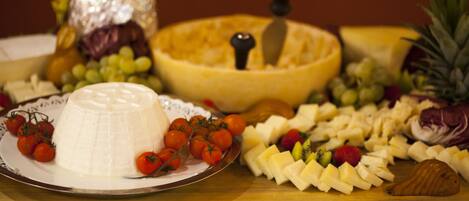 Una tabla de quesos con diferentes tipos de queso, frutas y verduras.