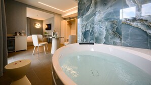 A modern bathroom with a large bathtub, marble walls, and a minimalist design.
