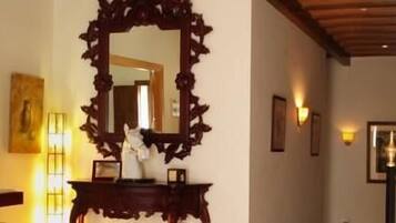 Una scala con corrimano in legno e uno specchio con cornice decorata fissato al muro.