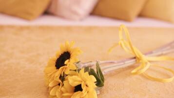 A bouquet of yellow flowers tied with a yellow ribbon on a textured surface.