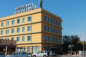 A multi-story hotel named MIRAMARE with a yellow facade and blue window frames. - Miramare (Catania)