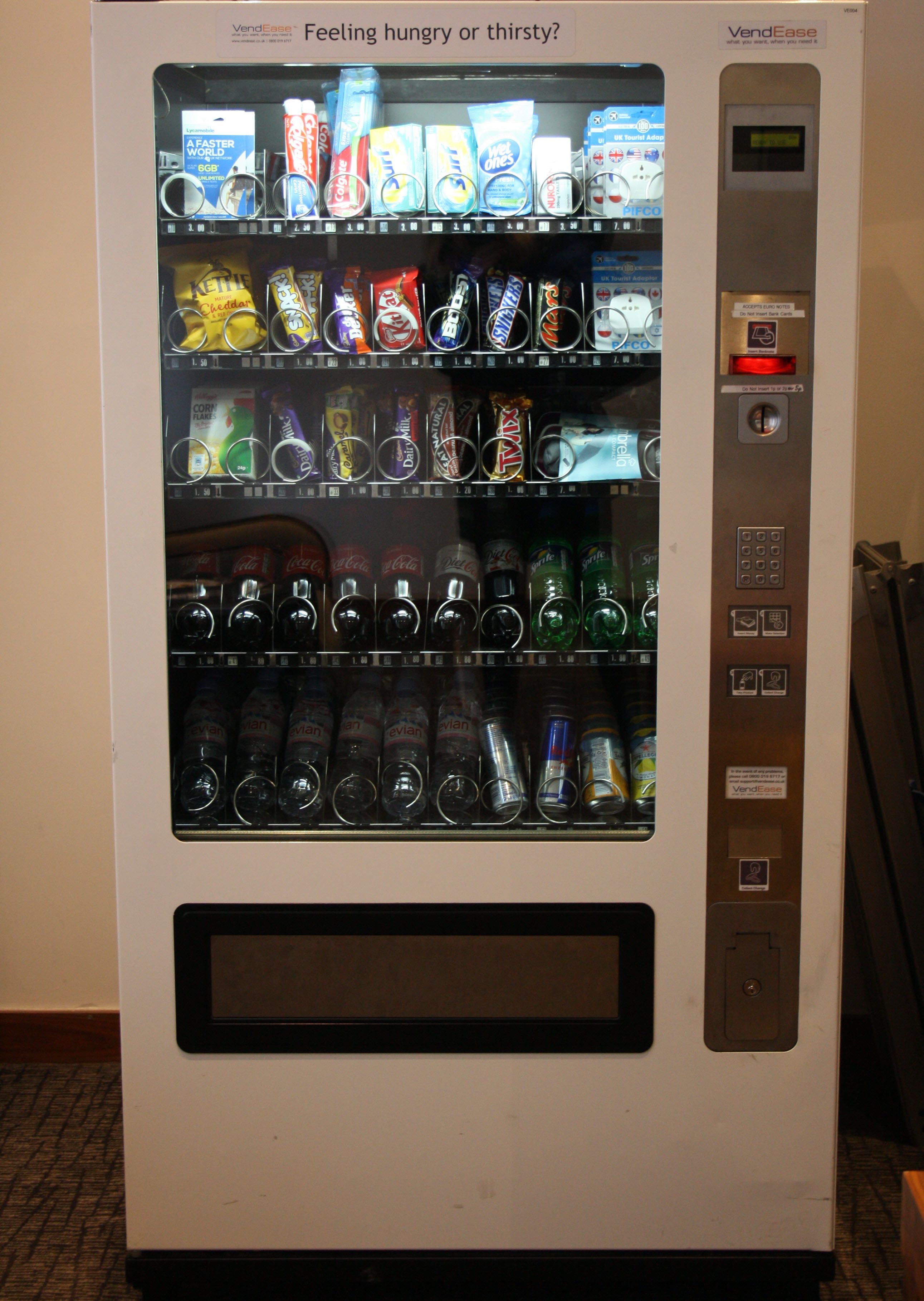 Un distributeur automatique proposant une variété de collations et de boissons.