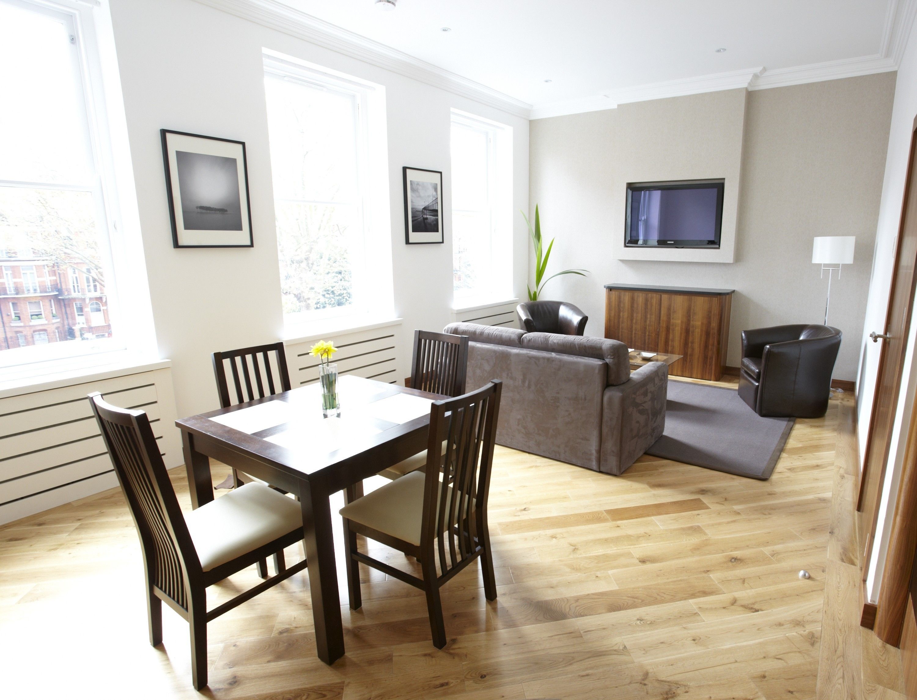 A modern living room with a dining table, sofa, and TV.