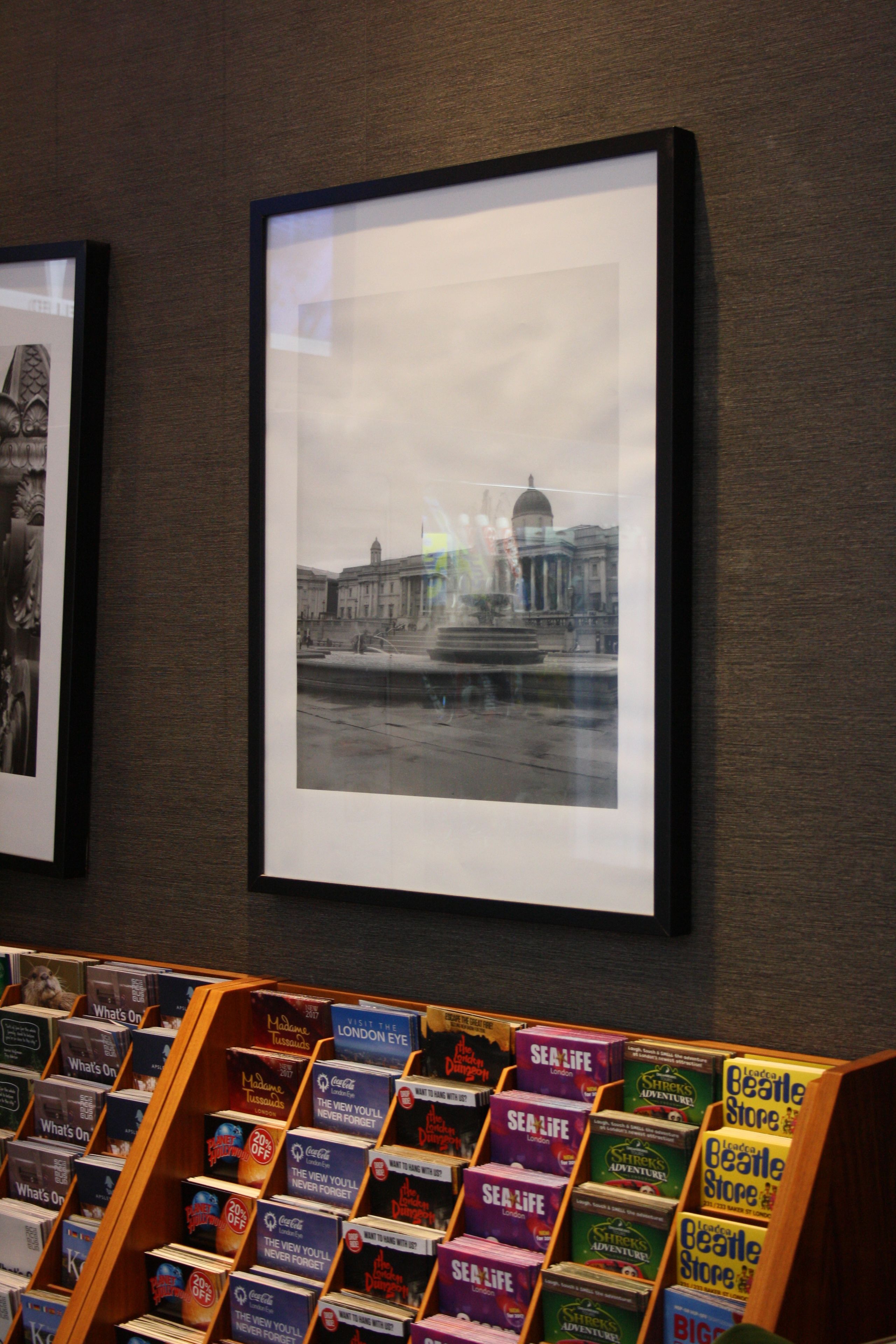 A bookstore with framed pictures on the wall and a display of books.