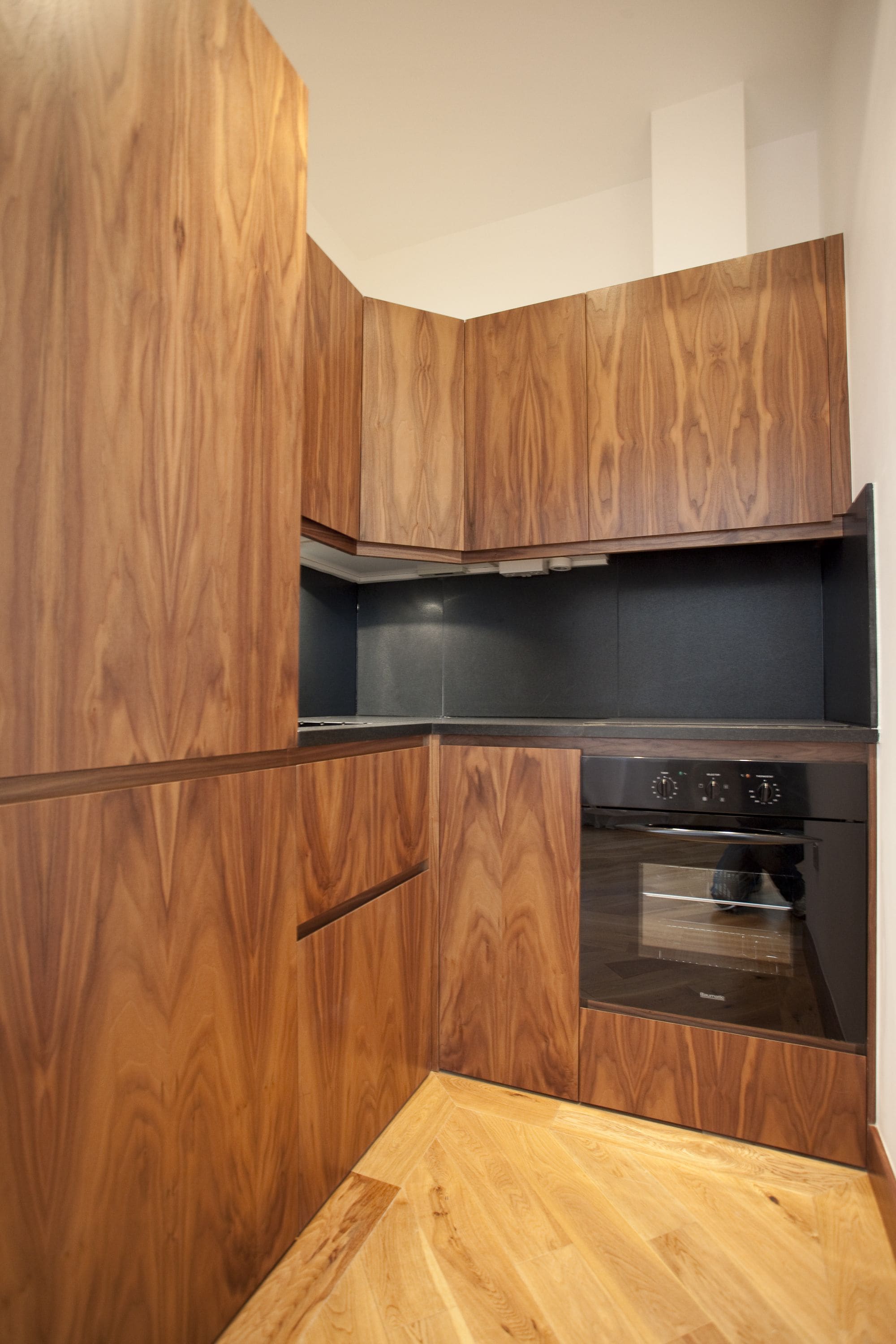 A kitchen with wooden cabinetry and a built-in oven.