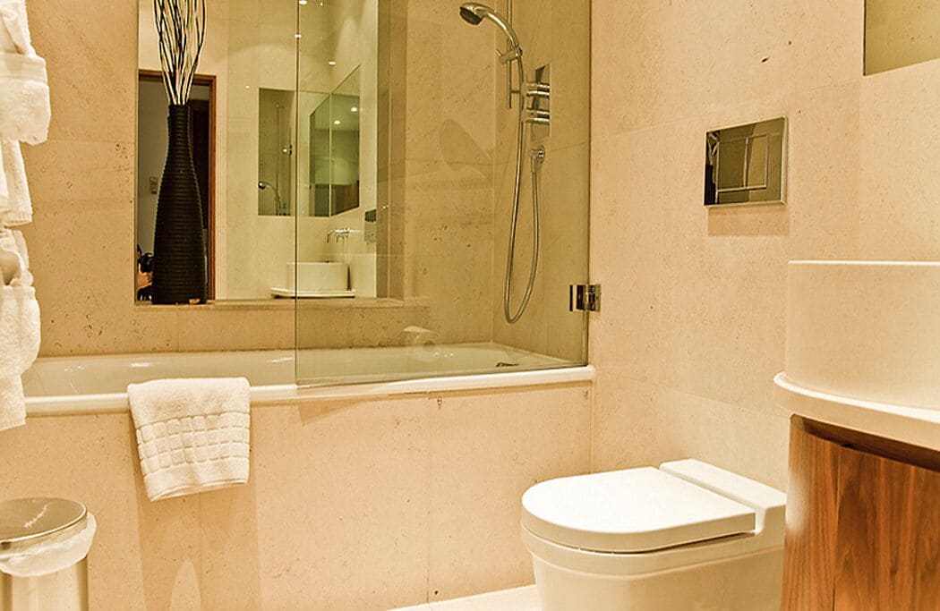A modern bathroom with a glass-enclosed shower, a standalone bathtub, and a toilet.