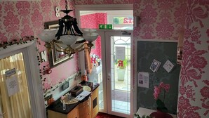Zona pranzo con lampadario, una scala e vista sull'esterno.
