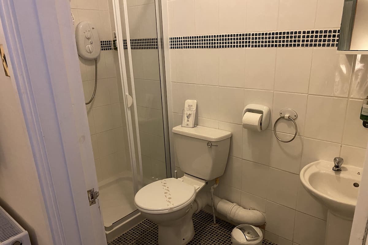 Um banheiro pequeno com vaso sanitário, bidê, pia e box de vidro.