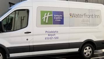 A white van with the Holiday Inn Express logo and "Waterfront Inn" text, parked at Philadelphia Airport.