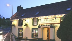 Um edifício com uma placa que diz 'Salutation Inn Country Hotel & Restaurant'.