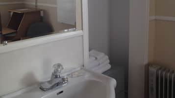 A bathroom with a sink, mirror, and towel rack.