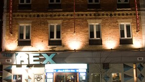 Un edificio con un letrero que dice "REX" y el número "194" en la fachada.