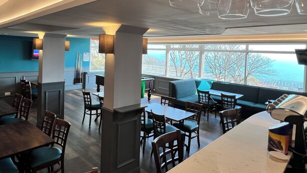 A modern restaurant with a pool table, seating areas, and a view of the ocean. - Cove Bay Hotel (Aberdeen)