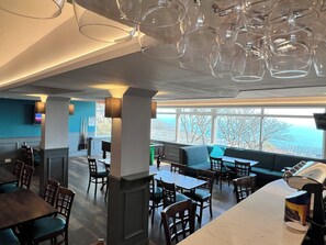 A modern restaurant with a pool table, seating areas, and a view of the ocean. - Cove Bay Hotel (Aberdeen)
