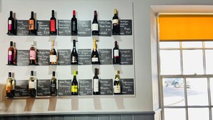 A wall with wine bottles and price tags. - Cove Bay Hotel (Aberdeen)