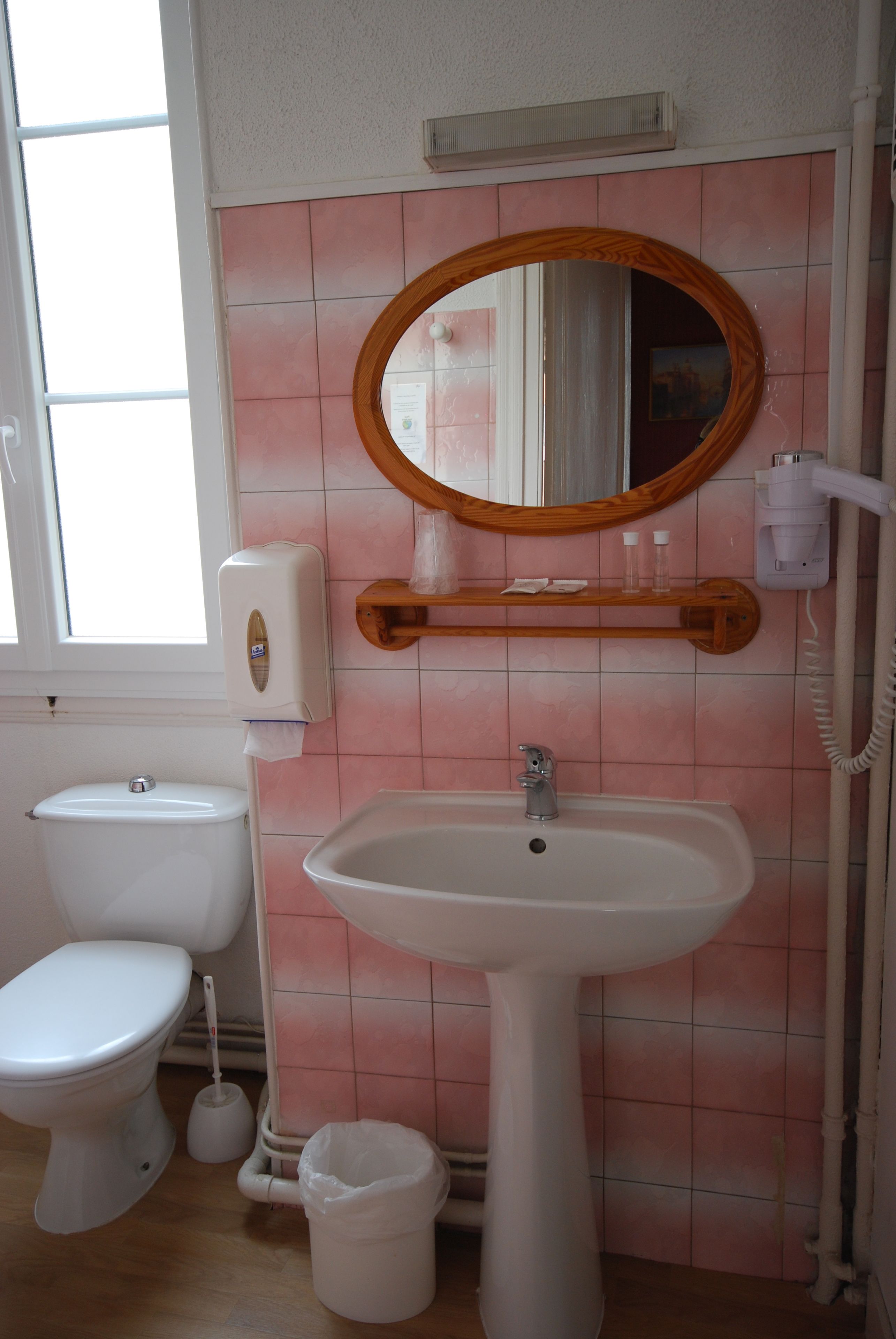 Un baño con inodoro, lavamanos y espejo.
