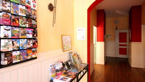 A hallway with a wall of travel brochures and a table with magazines.